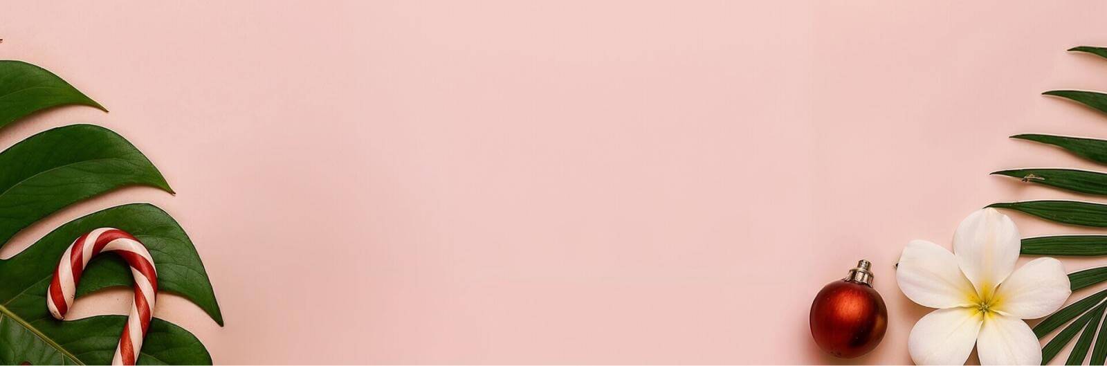 Fondo rosado con hoja verde, flor y adornos navideños.
