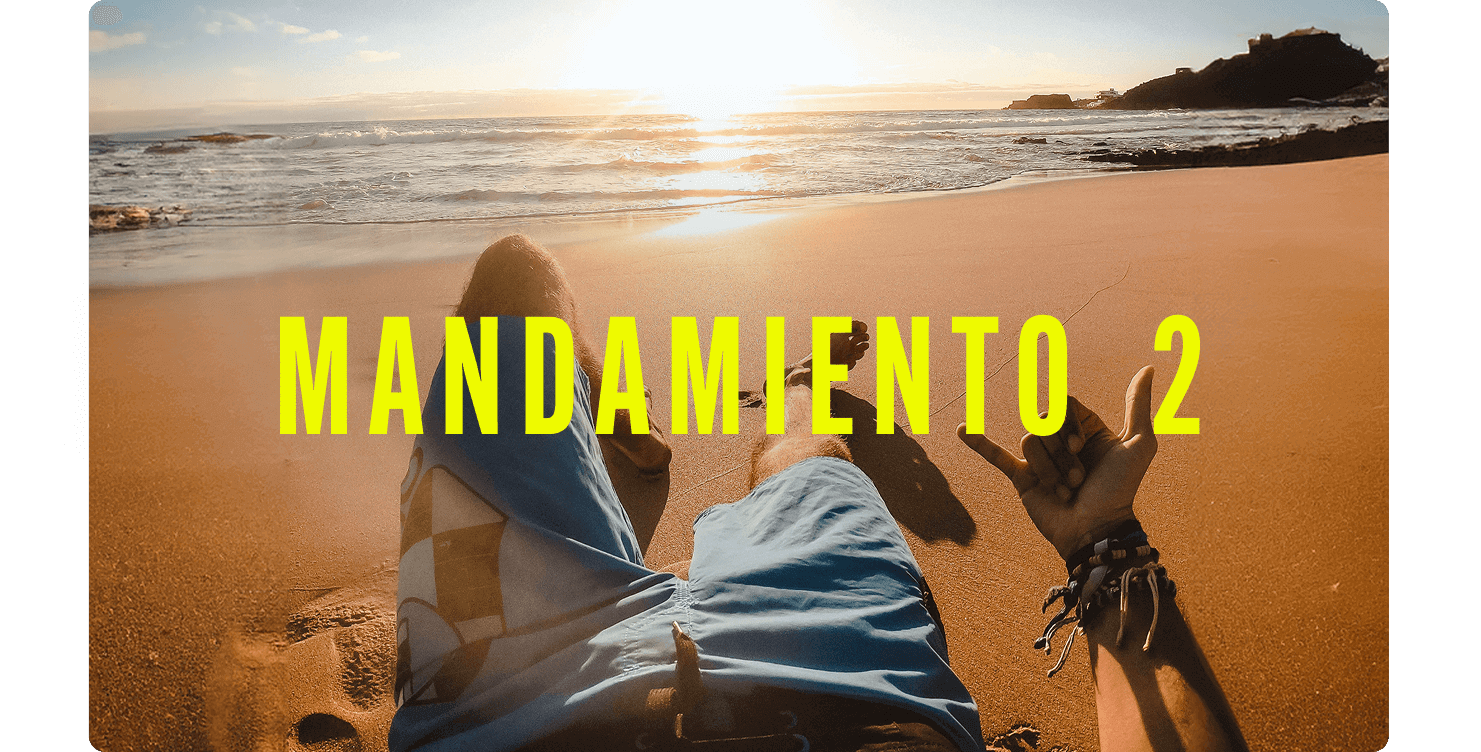 Punto de vista de una persona recostada en una playa de arena dorada, haciendo un gesto de aprobación con la mano.