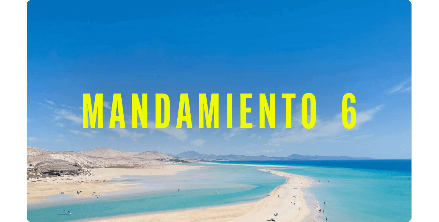 Vista aérea de una extensa playa de arena clara con mar turquesa y una lengua de arena que se adentra en el agua.