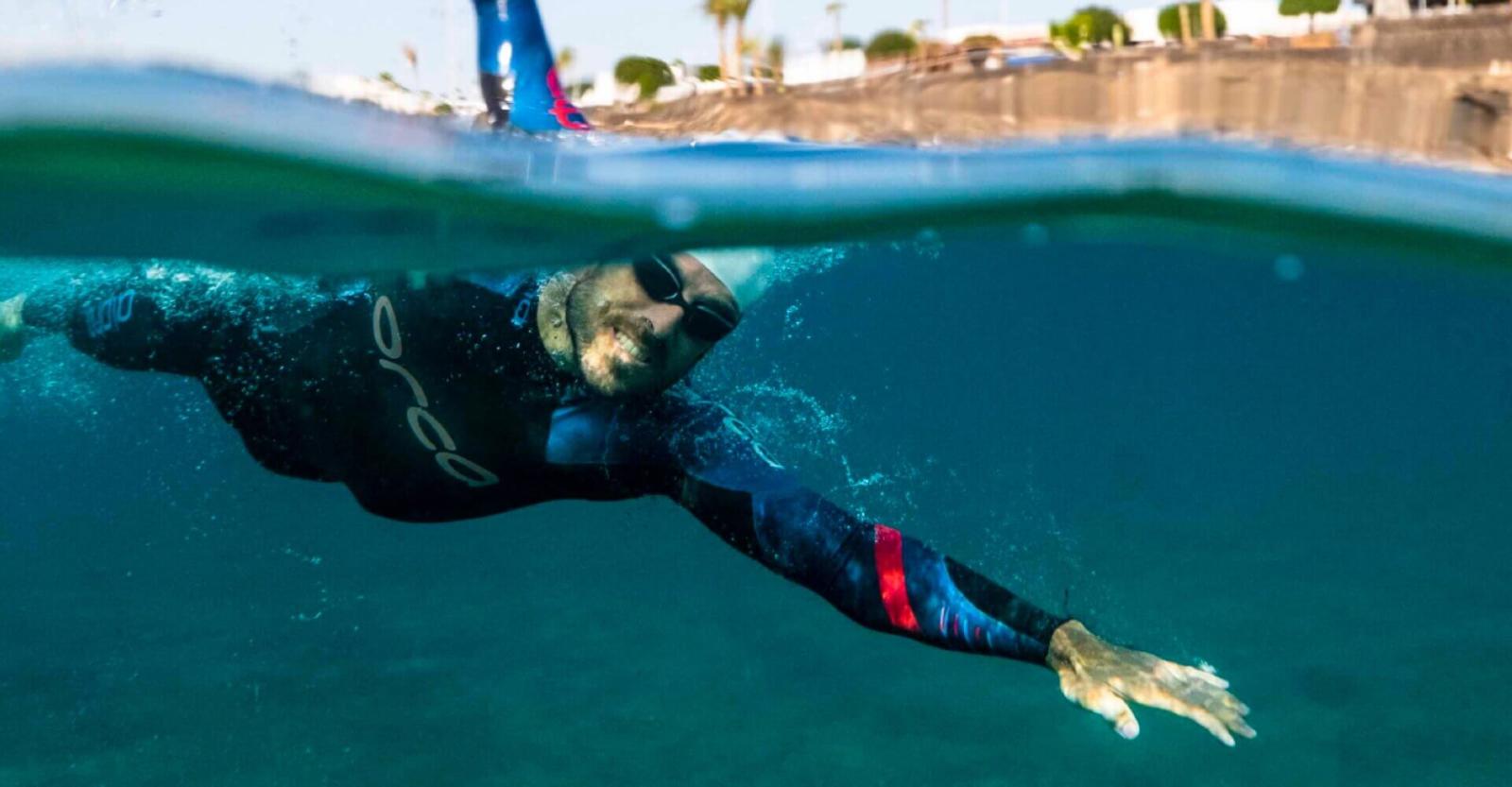 Persona nadando en aguas abiertas con traje de neopreno.