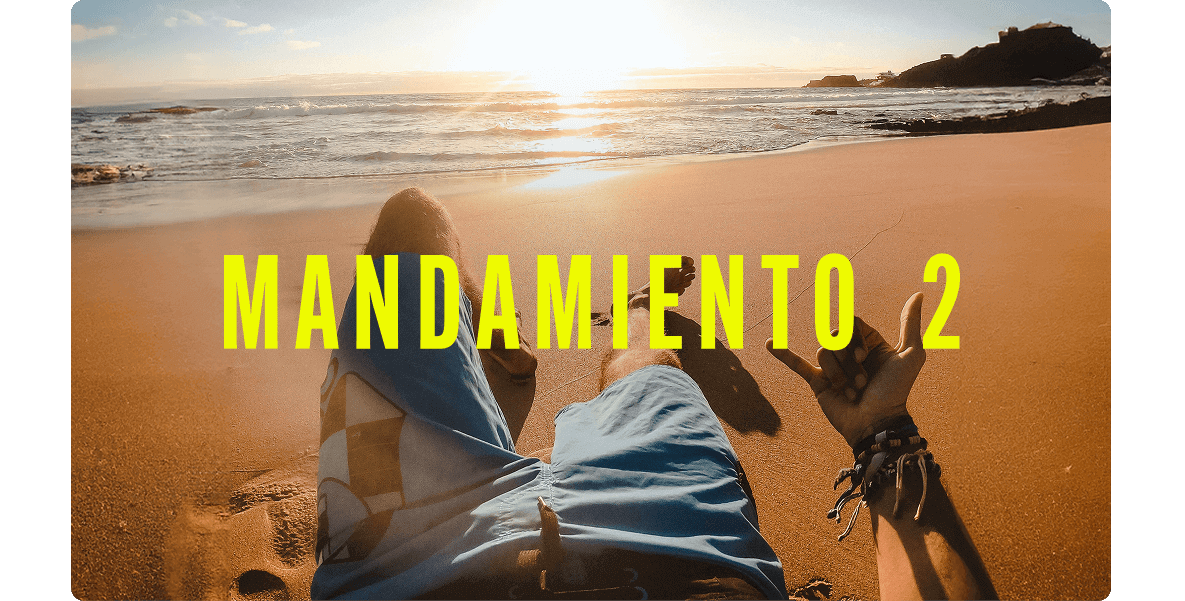 Punto de vista de una persona recostada en una playa de arena dorada, haciendo un gesto de aprobación con la mano.