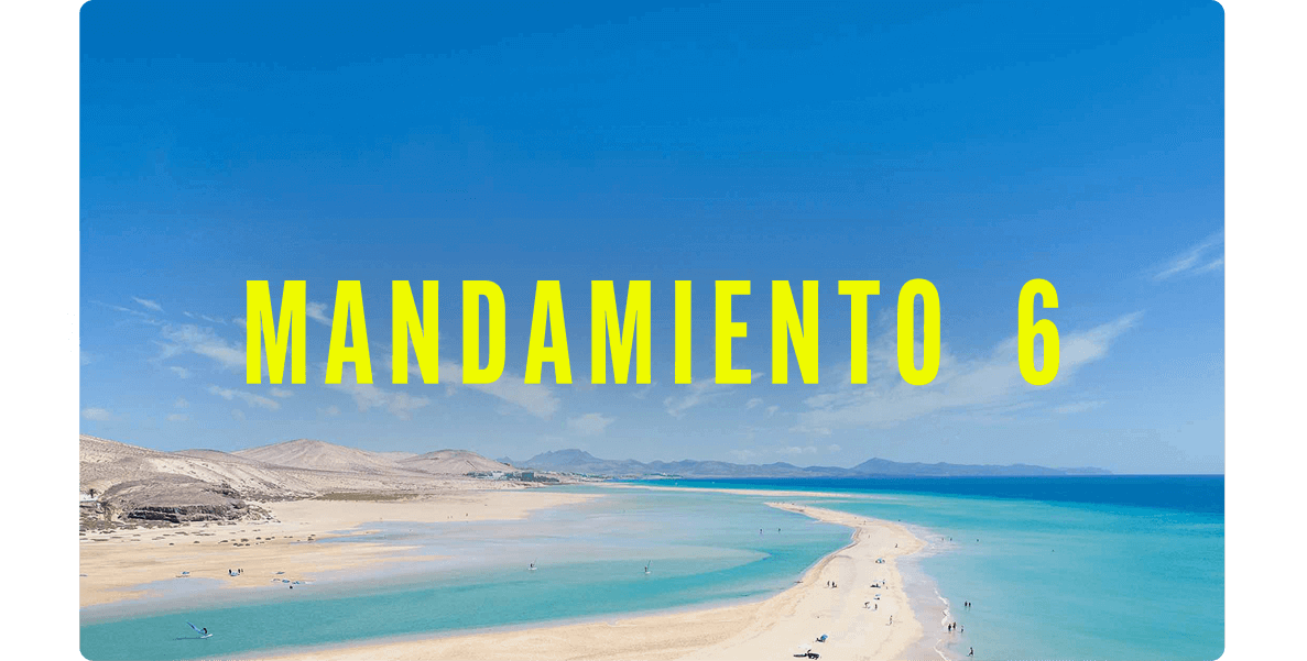 Vista aérea de una extensa playa de arena clara con mar turquesa y una lengua de arena que se adentra en el agua.