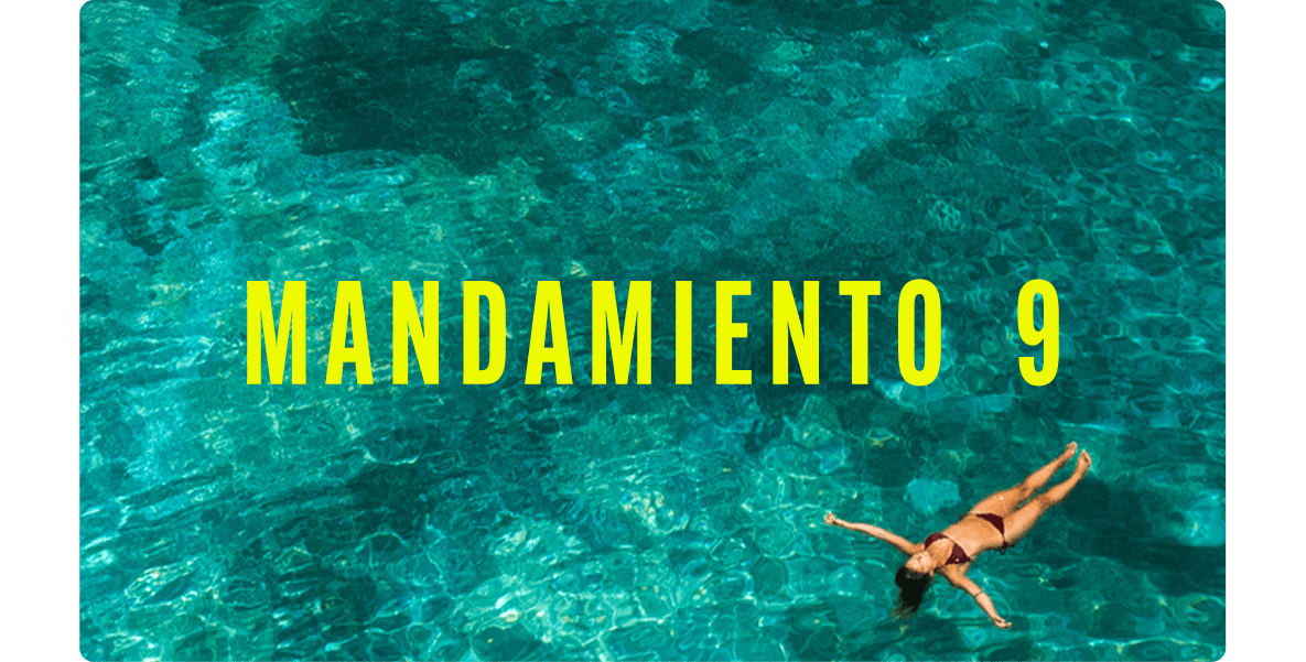 Persona flotando boca arriba en un mar transparente de tonos turquesa, vista desde arriba.